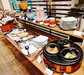 A buffet setup with various food items and utensils. - Hotel Scala 68 (Bogotá)