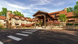 A stone building with a covered entrance and a crosswalk in front.