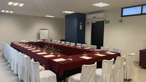 A conference room with a long table, white chairs, and a whiteboard. - Rymma Hotel (Morelia)
