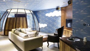 A modern living room with a sofa, a chair, a coffee table, and a unique ceiling structure. - All-Ur Boutique Motel - Tai-Tung Branch (Taitung)