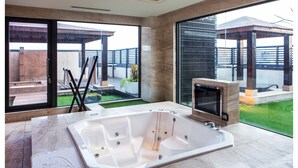 A modern bathroom with a large bathtub, a glass shower enclosure, and a view of a patio with a pergola. - All-Ur Boutique Motel KaoHsiung Branch (Kaohsiung)