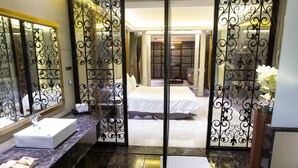 A hotel bathroom with a large mirror, a sink, and a bed visible through a decorative partition. - All-Ur Boutique Motel KaoHsiung Branch (Kaohsiung)
