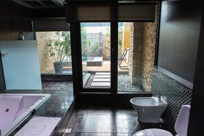 A modern bathroom with a bathtub, bidet, and a view of an outdoor garden area. - All-Ur Boutique Motel KaoHsiung Branch (Kaohsiung)