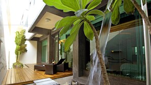 A modern indoor garden with a water feature, wooden flooring, and a seating area. - All-Ur Boutique Motel - Ping-Tung Branch (Pingtung)