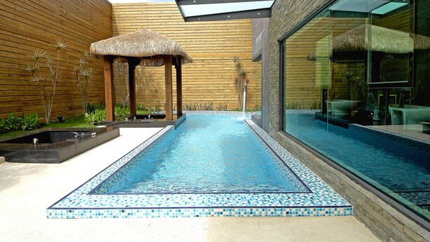 A modern outdoor pool area with a thatched gazebo, a clear glass enclosure, and a tiled border. - All-Ur Boutique Motel - Ping-Tung Branch (Pingtung)