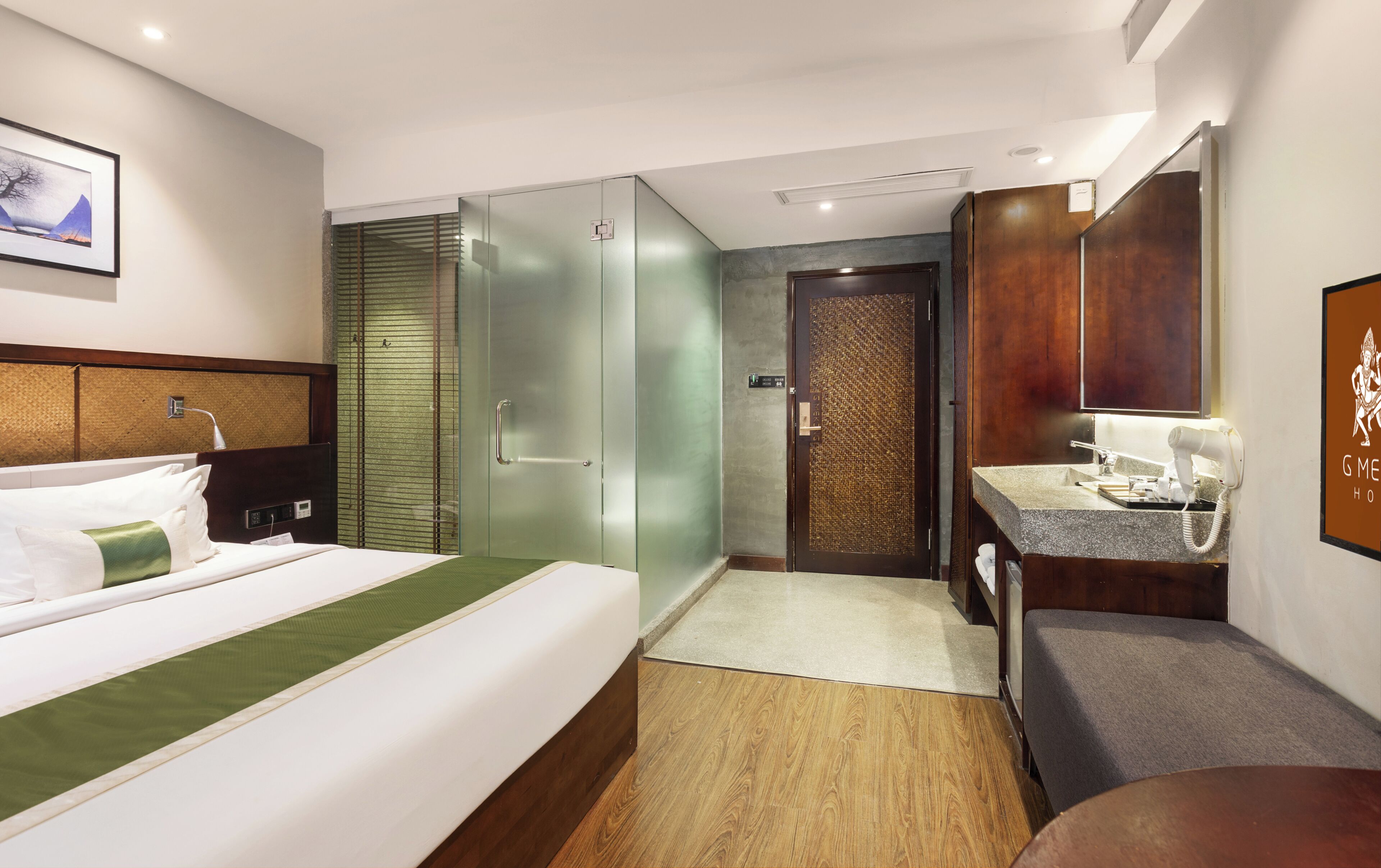 A hotel room with a bed, a bathroom with a mirror, and a shower area.