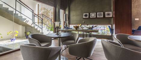 A modern interior with a staircase, seating area, and artwork on the walls.