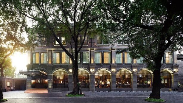 A historic building with large arched windows and a grand entrance. - The Gunawarman (Jakarta)