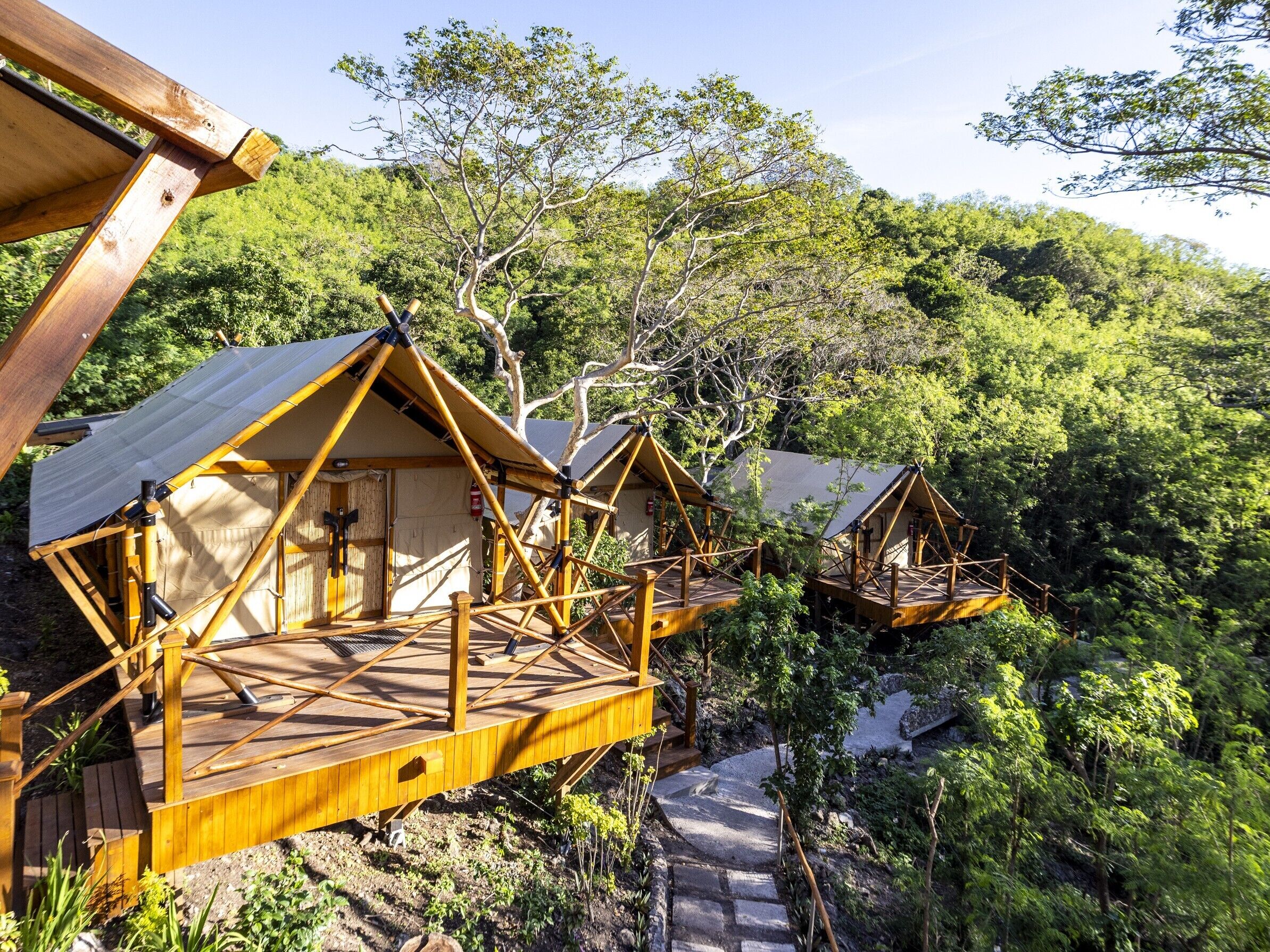 Elevated wooden cabins with a view of a forested landscape.