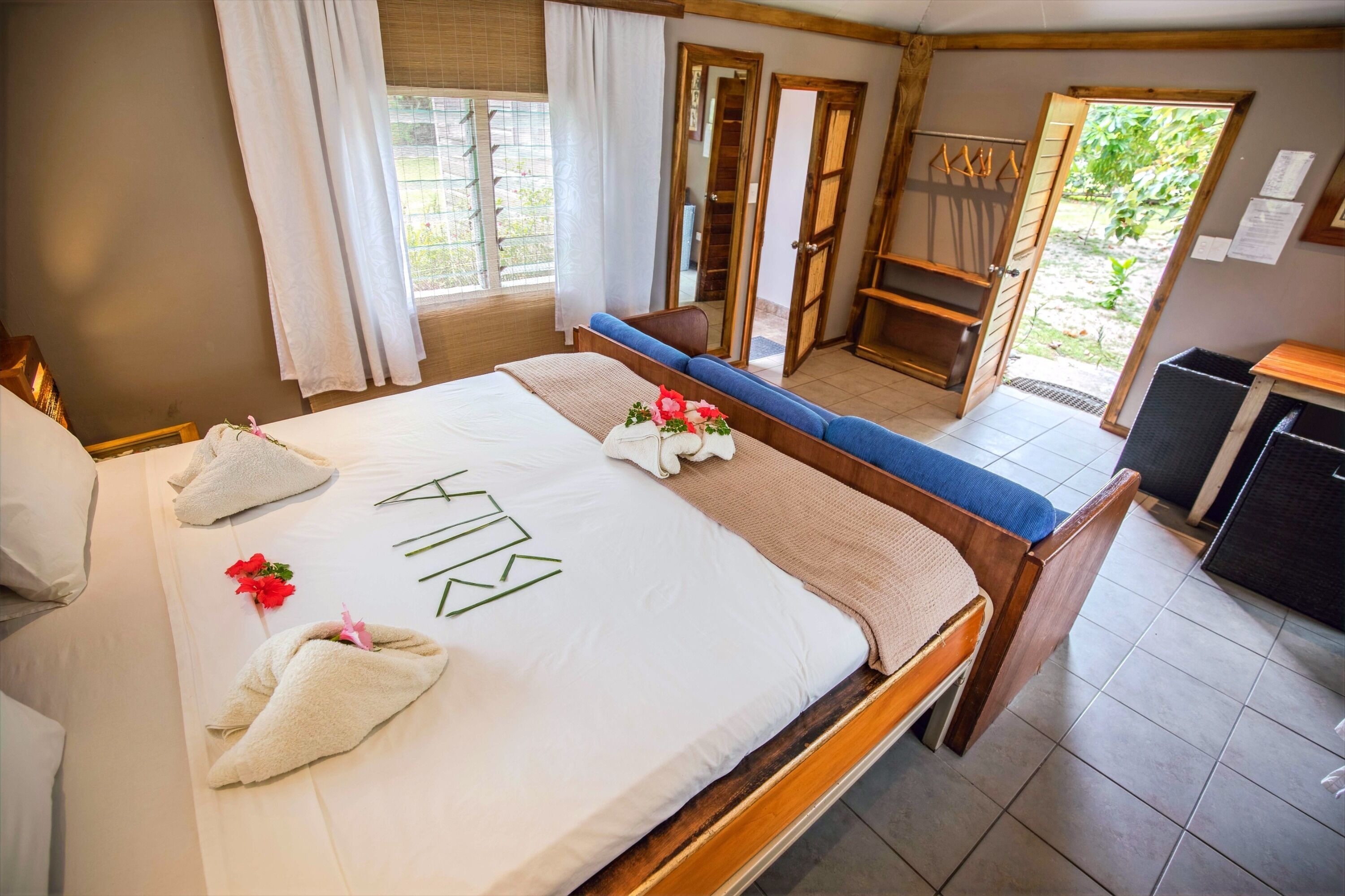Une chambre d’hôtel avec un lit, un canapé, un bureau et une fenêtre avec des rideaux.