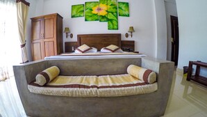 A bedroom with a bed, a sofa bed, a wooden wardrobe, and a wall with three floral paintings. - Hotel Sunrich Kandy (Hedeniya)