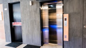 An elevator with a digital display and a sign indicating a WiFi zone.
