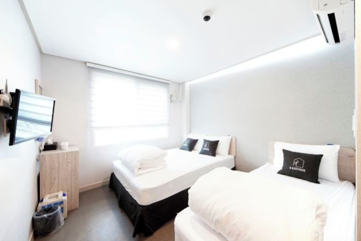 A modern hotel room with a bed, a desk, and a window.
