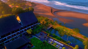 A resort with a beach view, a pool area, and a dining terrace.
