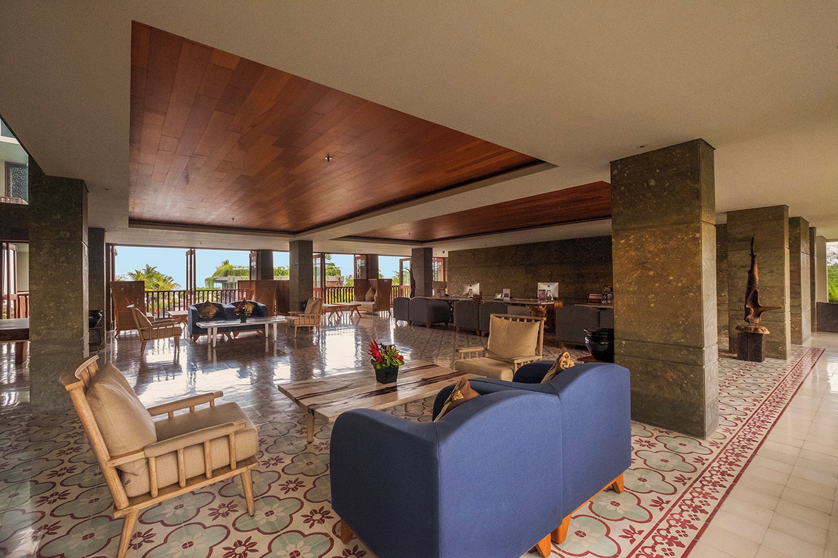 A spacious lobby with a wooden ceiling, large seating area, and a view of the outdoors.