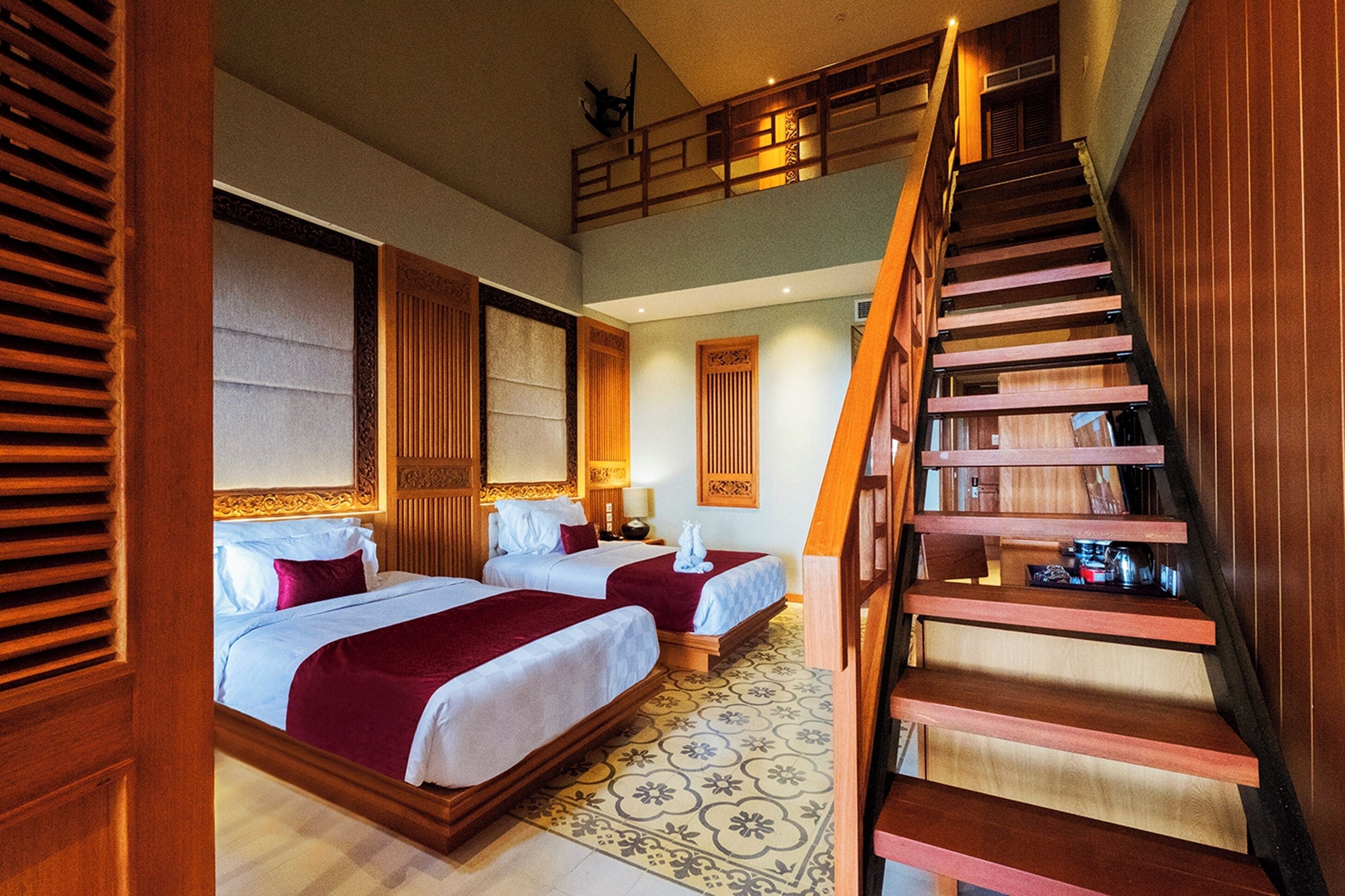 Ein Hotelzimmer mit zwei Betten, einer Holztreppe und einem Balkon.