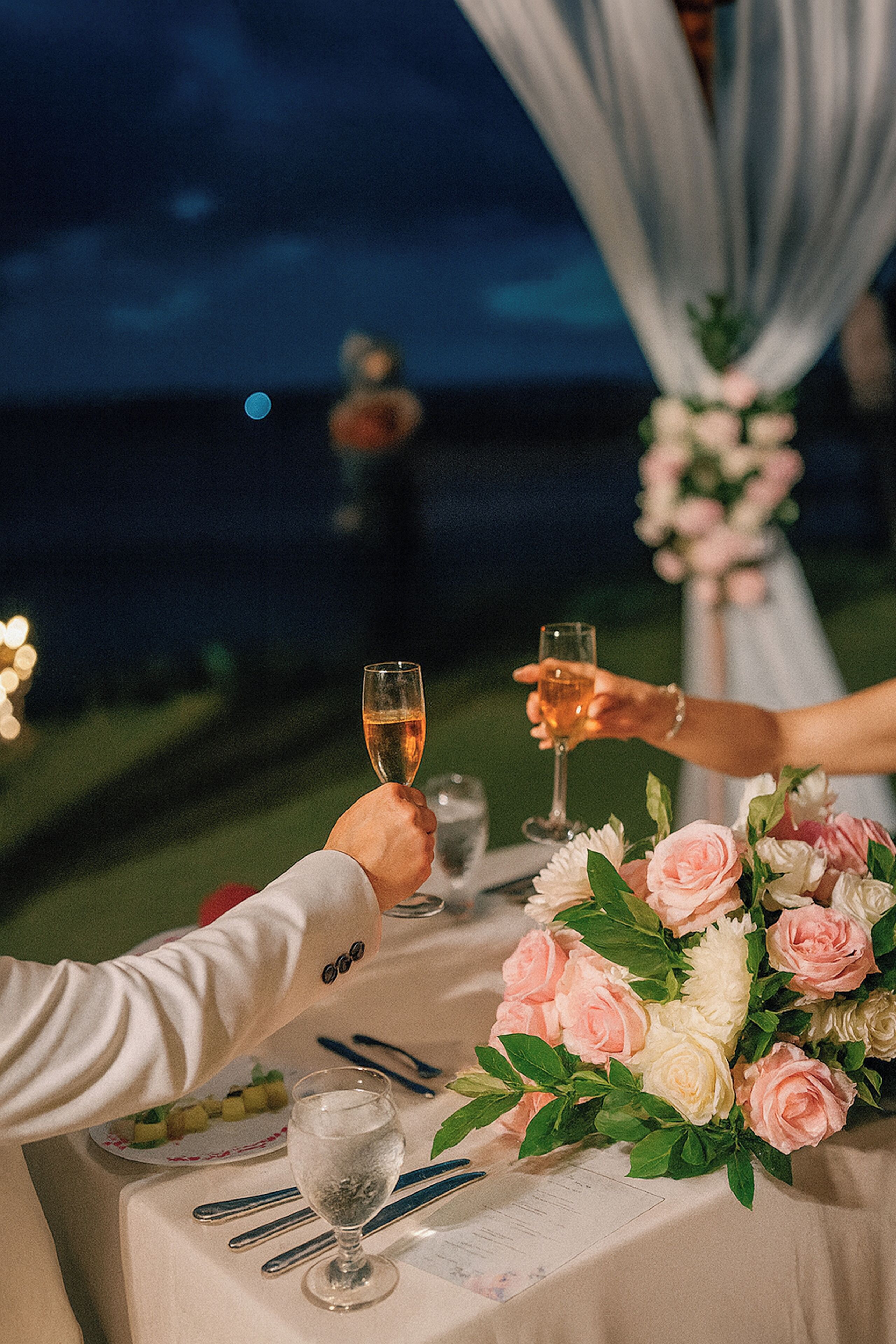A table set for a meal with a floral centerpiece, a glass of water, and a glass of wine.