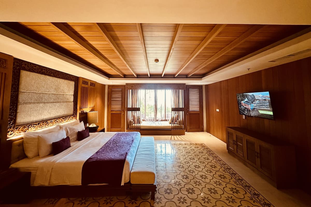 Een ruime slaapkamer met een groot bed, een televisie en uitzicht op de omgeving.
