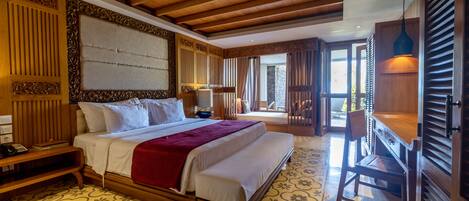 Un dormitorio amplio con una cama grande, cabecera de madera y un escritorio con silla.