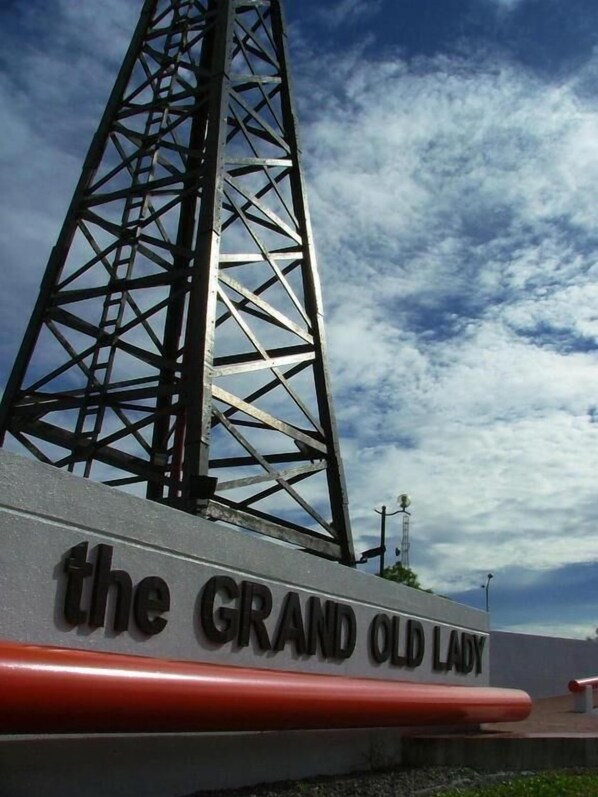 Um letreiro com o texto 'the GRAND OLD LADY' ao fundo de uma estrutura metálica e um céu parcialmente nublado.