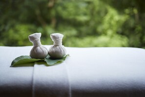 Two small white objects on a white surface with a green leaf, set against a blurred green background. - Hakone Retreat Före (Hakone)