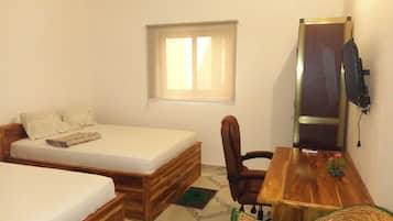 Une petite pièce comprenant un lit, un bureau, une chaise, une fenêtre et un téléviseur.