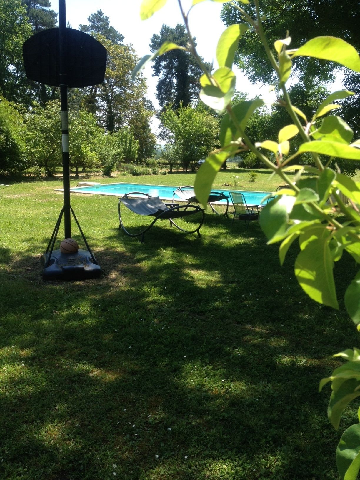 Ein Poolbereich mit Liegestuhl und Basketballkorb.