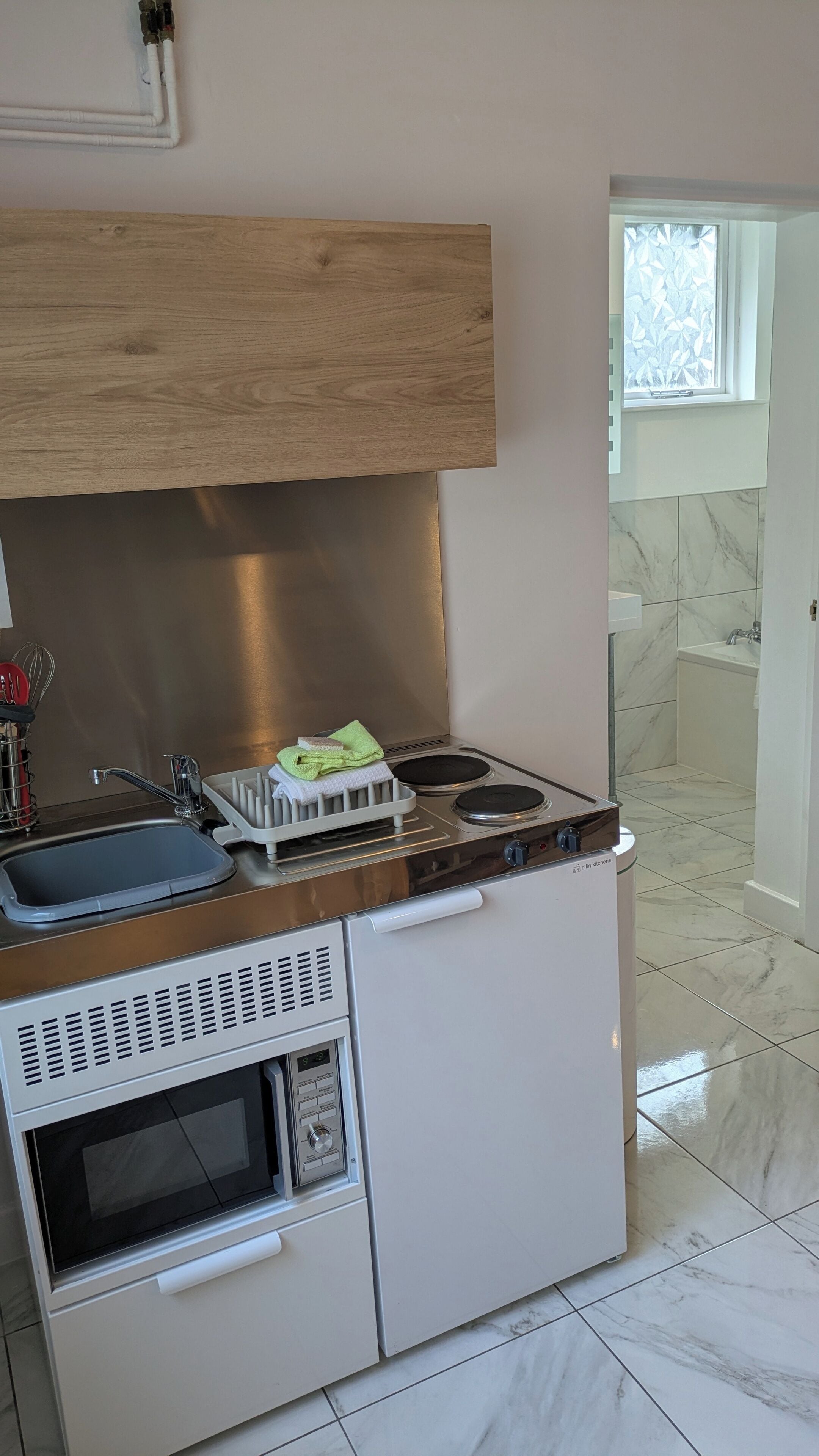A compact kitchen with a stove, oven, and sink.