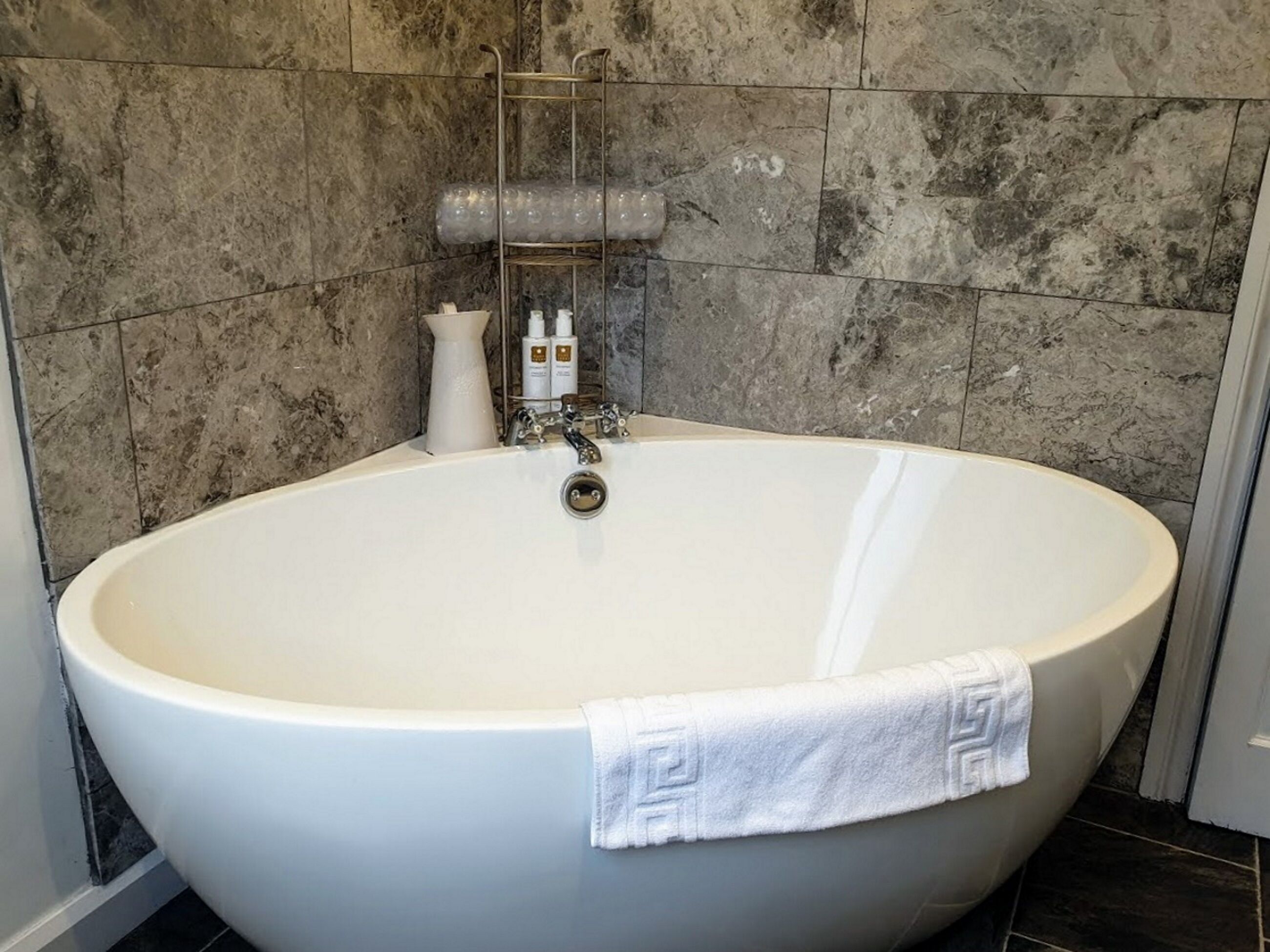 A large, round bathtub with a white towel draped over the side.