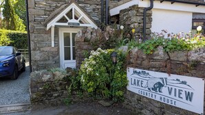 Un bâtiment en pierre sur lequel est apposée une enseigne indiquant : « Résidence de campagne avec vue sur le lac ».