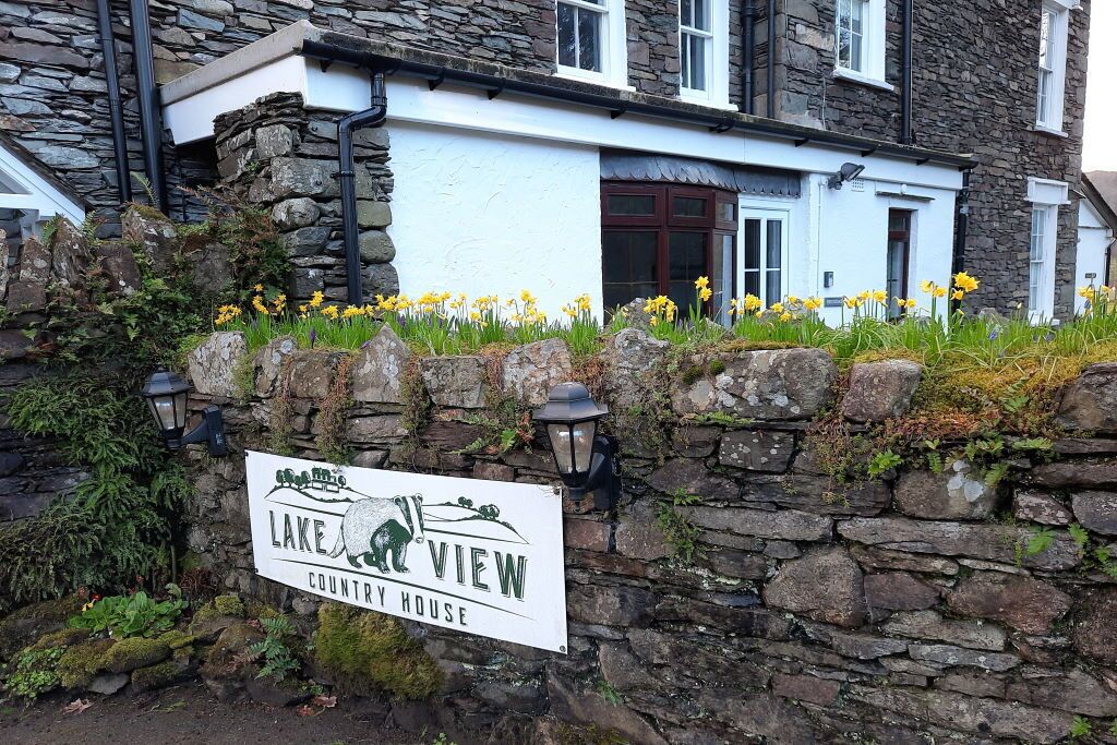 A stone wall with a sign for Lake View Country House.