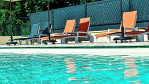 A poolside area with lounge chairs and a covered umbrella. - Hôtel du Viaduc (Tarascon)