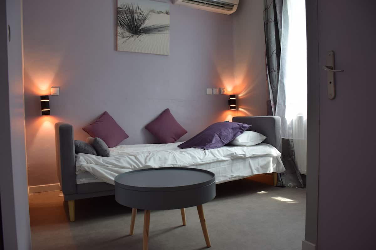 Ein modernes Schlafzimmer mit einem Bett, einem kleinen runden Tisch und zwei Wandleuchten.
