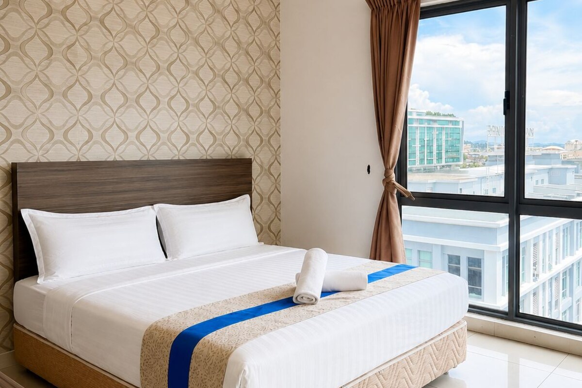Ein Hotelzimmer mit einem großen Bett, Blick auf die Stadt und einem gemusterten Wandpapier.