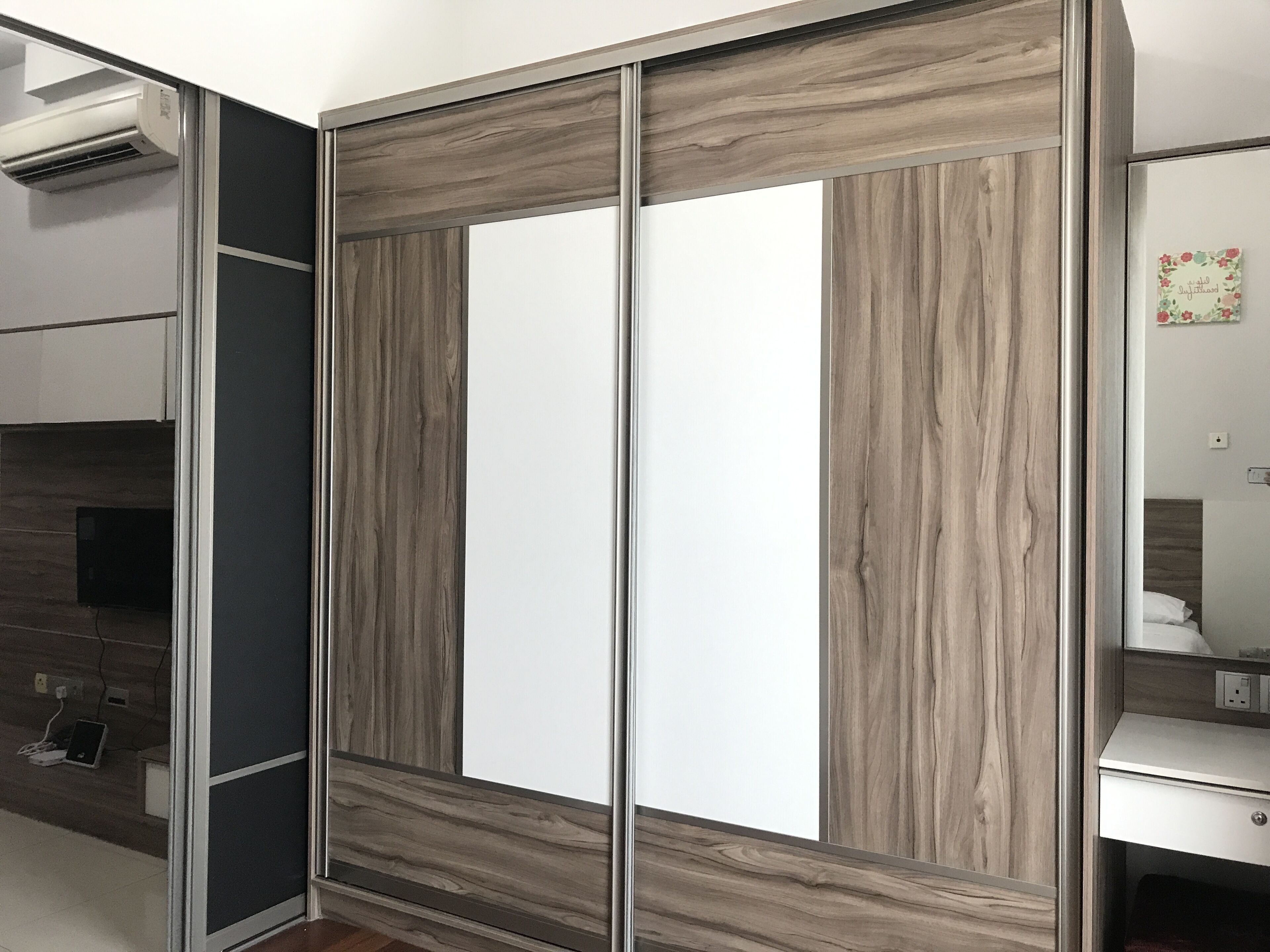 Un armario con detalles de madera y puertas de espejo.