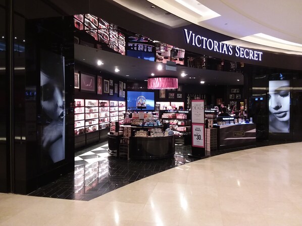 Un magasin Victoria's Secret avec une enseigne bien visible, un intérieur bien éclairé et une variété de produits de beauté exposés.