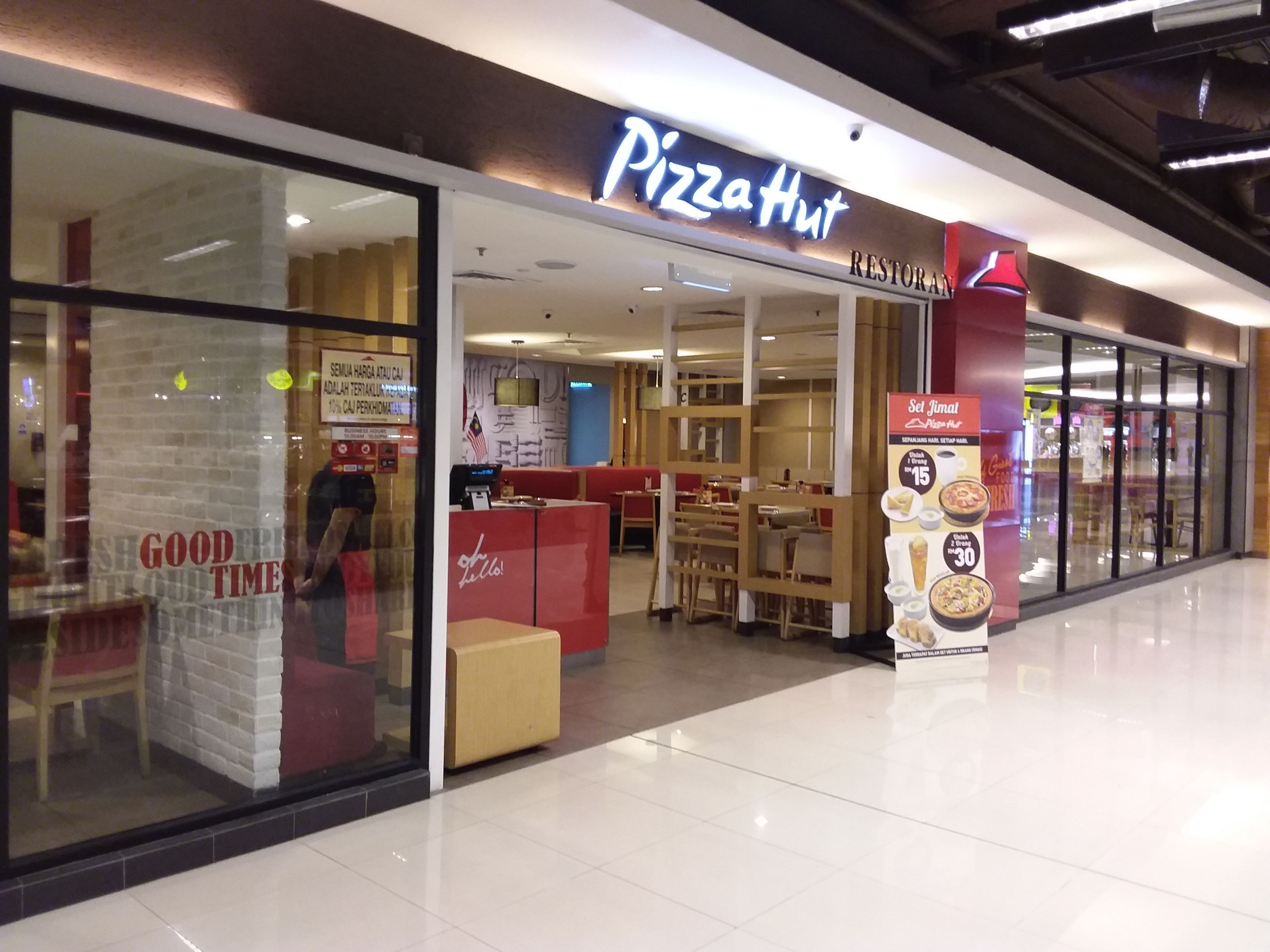 A Pizza Hut restaurant with a modern interior, including a counter and seating area.
