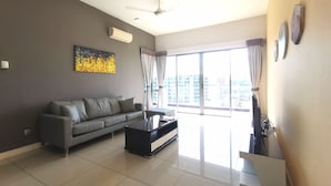 A modern living room with a grey sofa, a black coffee table, and a ceiling fan.
