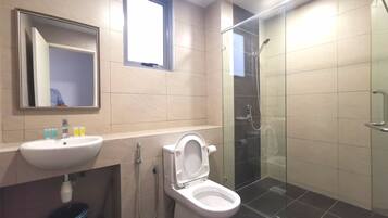 Een moderne badkamer met een wastafel, toilet en douchecabine met glazen wanden.