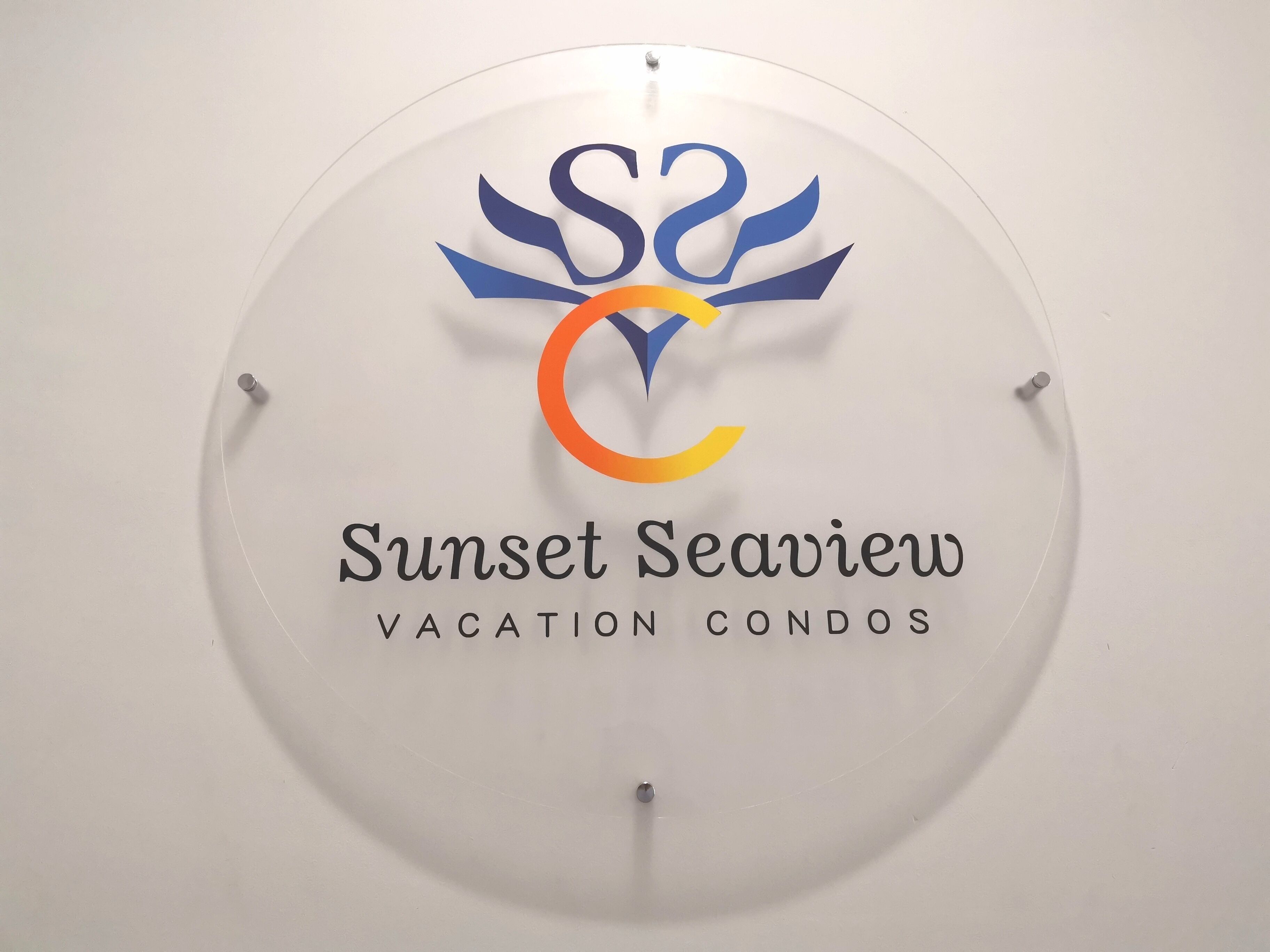 A circular sign with a logo and text for Sunset Seaview Vacation Condos.