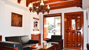 Un intérieur de style traditionnel avec un canapé, une table basse en bois et une grande porte en bois.
