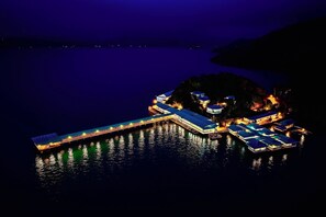 Un resort frente al agua con múltiples bungalows sobre el agua unidos por un puente.