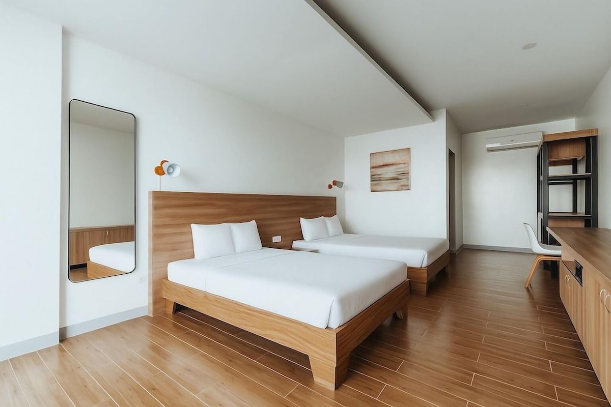 Una habitación de hotel moderna con una cama grande, un escritorio y un armario.