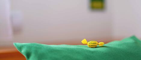 Un cojín verde con un pequeño objeto amarillo encima.