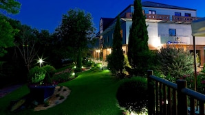 Ein modernes Hotel mit einem gut beleuchteten Gartenweg, der zum Eingang führt.