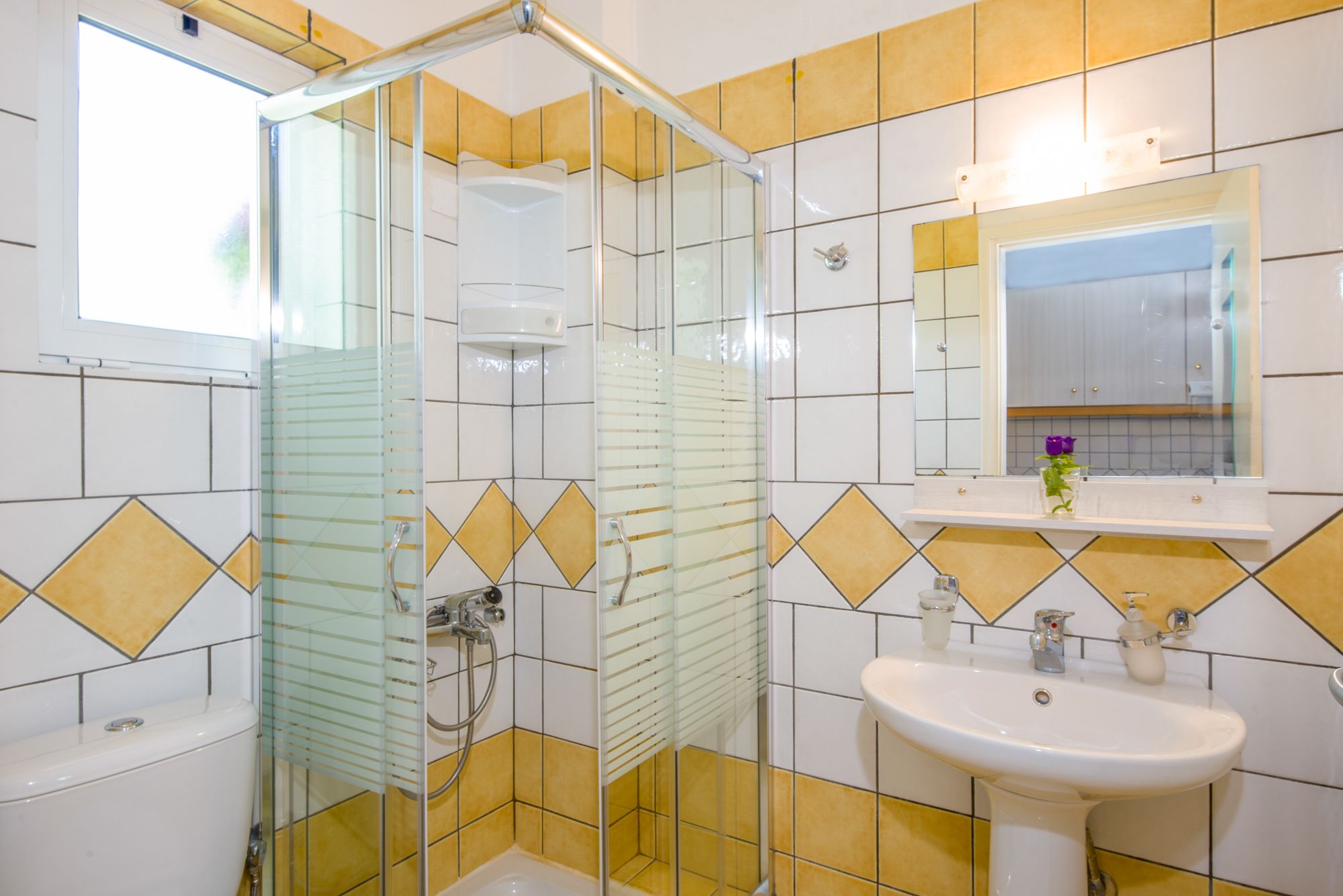 Ein Badezimmer mit Duschkabine, Waschbecken und Spiegel darüber.