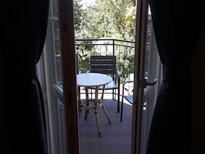 An open door to an outdoor patio with a table and chairs. - Imperial-Apartments Schönbrunn (Vienna)