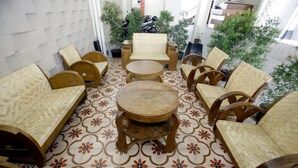 Quarto com chão estampado, mobiliário de madeira e plantas em vasos.
