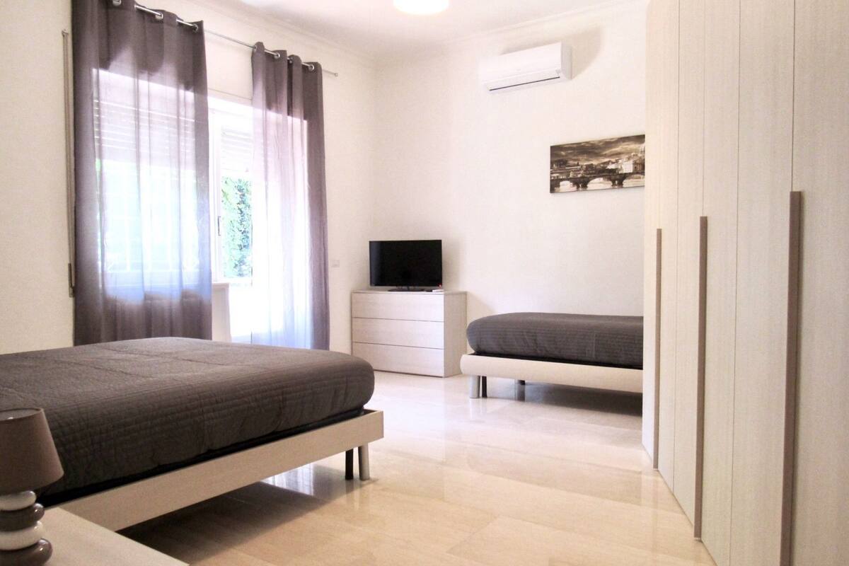 A bedroom with a bed, a TV, a dresser, and a wardrobe.