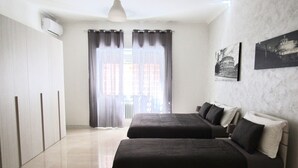 A modern bedroom with two beds, a wardrobe, and a large window with curtains. - Roema Guest House (Rome)